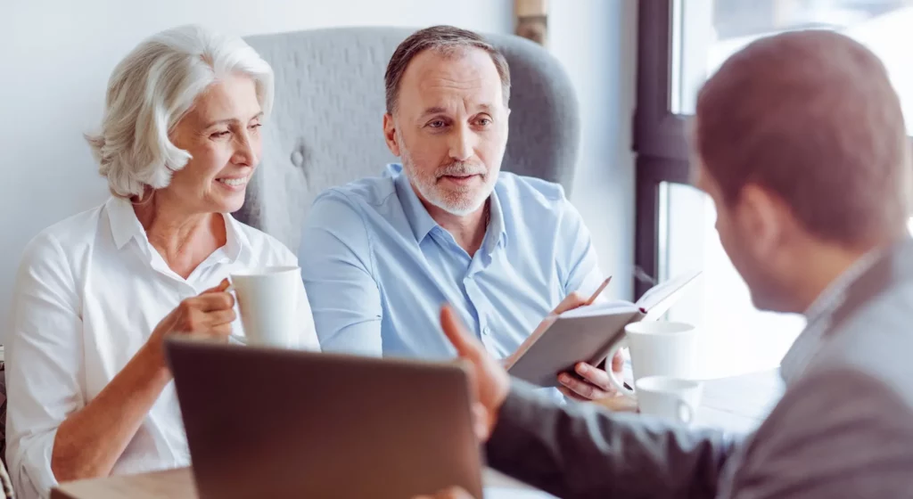 Conseiller funéraire présentant un contrat d'assurance obsèques à un couple.